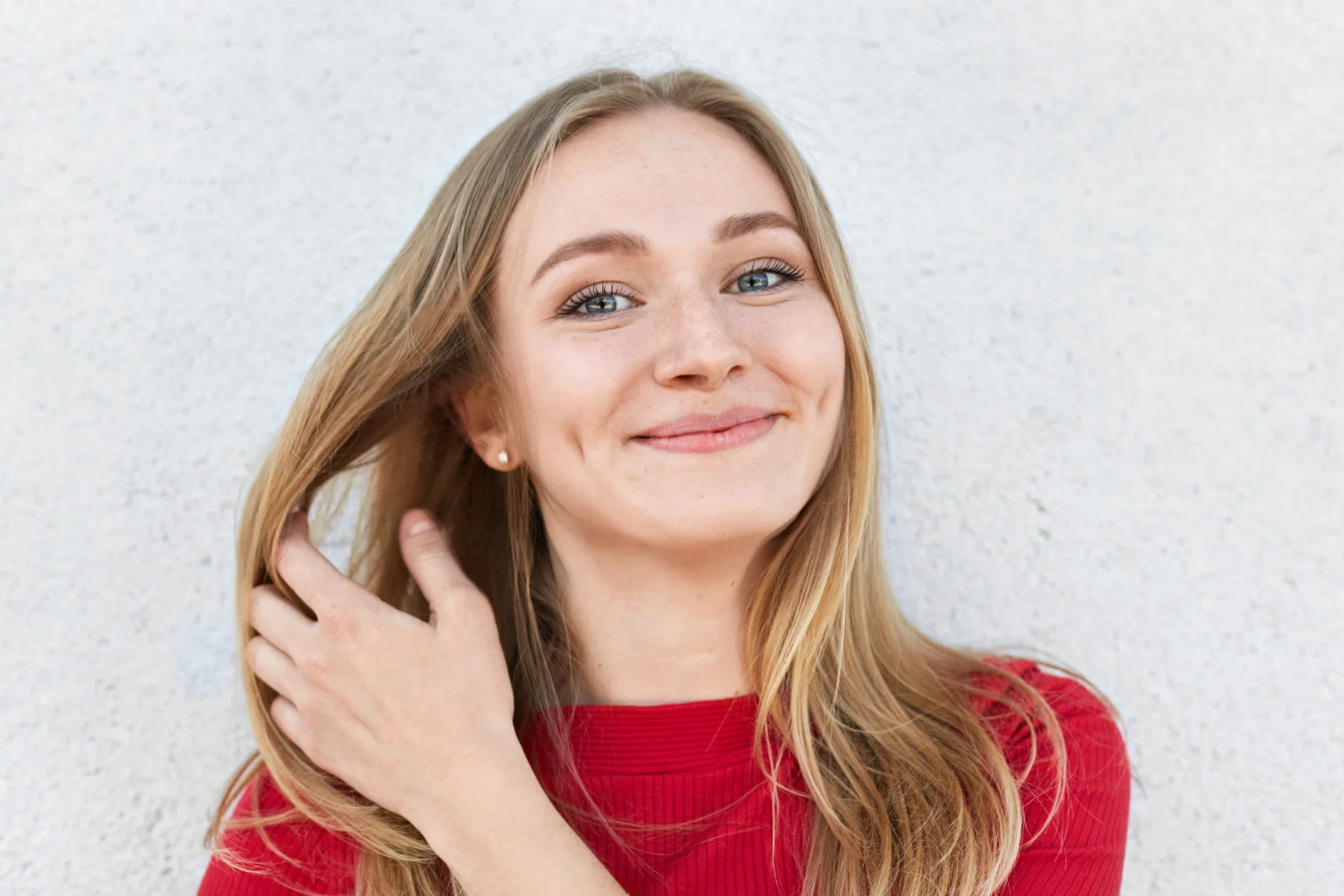 Pleased woman with blonde hair luminous eyes gentle smile having dimples cheeks